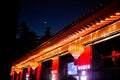 Red light up on the Chinese temple under the crescent moon.