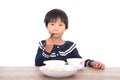 Chinese three year old girl eating at the table in front of white background