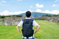 A chinese tourist in the ruins of the architecturally significant Mesoamerican pyramids and green grassland located at at