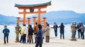 Chinese tourists are taking photo of Miyajima Torii.