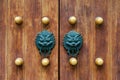 Chinese traditional doorknob and wooden doors. Old handle of metal on a wooden old door. Door knocker in the shape of a Royalty Free Stock Photo