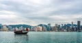 Chinese traditional junk boat in front of Hong Kong skyline Royalty Free Stock Photo