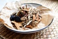 Chinese traditional medicine script. Herbal tea with jujubes, goji berries, gingseng roots and others on parchment paper on neutra