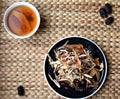 Chinese traditional medicine script. Herbal tea with jujubes, goji berries, gingseng roots and others on parchment paper on neutr