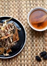 Chinese traditional medicine script. Herbal tea with jujubes, goji berries, gingseng roots and others on parchment paper on neutr