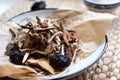 Chinese traditional medicine script. Herbal tea with jujubes, goji berries, gingseng roots and others on parchment paper on neutra