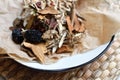 Chinese traditional medicine script. Herbal tea with jujubes, goji berries, gingseng roots and others on parchment paper on neutra