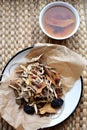 Chinese traditional medicine script. Herbal tea with jujubes, goji berries, gingseng roots and others on parchment paper on neutra