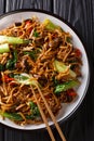 Chinese udon noodles with bok choy, shiitake and pepper close-up on a plate. Vertical top view Royalty Free Stock Photo