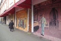 Old man walking past Chinatown murals
