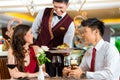 Chinese waiter serving dinner in elegant restaurant or Hotel Royalty Free Stock Photo