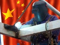 CHinese welder with his flag in the background