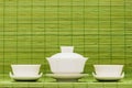 Chinese white ceramic tea set over green bamboo mat background Royalty Free Stock Photo