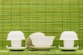 Chinese white ceramic tea set over green bamboo mat background Royalty Free Stock Photo