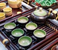 Chinese white teapot and teacups on the wooden trivet Royalty Free Stock Photo