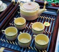 Chinese white teapot and teacups on the wooden trivet Royalty Free Stock Photo