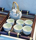 Chinese white teapot and teacups on the wooden trivet Royalty Free Stock Photo