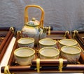 Chinese white teapot and teacups on the wooden trivet Royalty Free Stock Photo