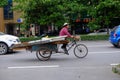 Chinese woman on bicycle carrying materials in China