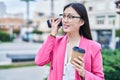 Chinese woman business worker listening voice message by smartphone drinking coffee at park Royalty Free Stock Photo