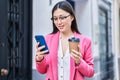 Chinese woman business worker using smartphone drinking coffee at street Royalty Free Stock Photo