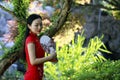 Chinese woman in cheongsam by a lake in Mudu ancient town