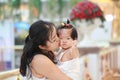 Chinese woman kiss her sweet baby girl on a mall Royalty Free Stock Photo