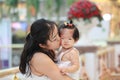 Chinese woman kiss her sweet baby girl on a mall Royalty Free Stock Photo