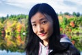 Chinese woman looking at the camera with fall foliage background