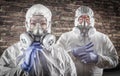 Chinese Woman and Man In Gas Masks, Goggles and Hazmat Suites Against Brick Background Royalty Free Stock Photo