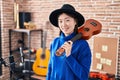 Chinese woman musician smiling confident holding ukulele at music studio