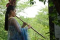 Chinese woman playing bamboo flute Royalty Free Stock Photo