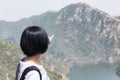 A chinese woman pointing at the great wall of china