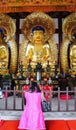 Chinese woman praying in front of Buddha Statue