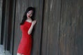 A Chinese woman in red dress lying on a woodern ancient door