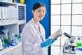 Chinese woman scientist smiling confident reading book at laboratory Royalty Free Stock Photo