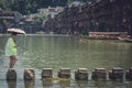 Chinese woman on stepping stones in Fenghuang