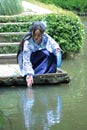 Chinese woman in traditional Blue and white Hanfu dress Sit on the steps and paddle