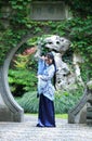 Chinese woman in traditional Blue and white Hanfu dress Standing in the middle of beautiful gate