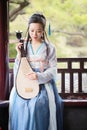 Chinese woman in traditional Hanfu dress,play traditional instrument of pipa