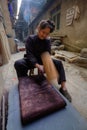 Chinese woman vigorously pounding cloth to make it shine, China.