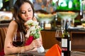 Chinese woman waiting in restaurant for date Royalty Free Stock Photo