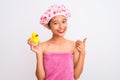 Chinese woman wearing shower towel and cap holding duck toy over isolated white background happy with big smile doing ok sign, Royalty Free Stock Photo