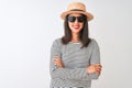 Chinese woman wearing striped t-shirt hat sunglasses standing over isolated white background happy face smiling with crossed arms Royalty Free Stock Photo