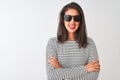 Chinese woman wearing striped t-shirt and sunglasses standing over isolated white background happy face smiling with crossed arms Royalty Free Stock Photo