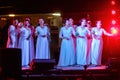 Chinese women in white dresses singing on stage Royalty Free Stock Photo