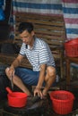 Chinese person peeling skin off small fish