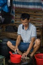Chinese person peeling skin off small fish