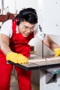 Chinese worker on saw in industrial factory Royalty Free Stock Photo