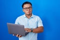 Chinese young man using computer laptop skeptic and nervous, frowning upset because of problem Royalty Free Stock Photo